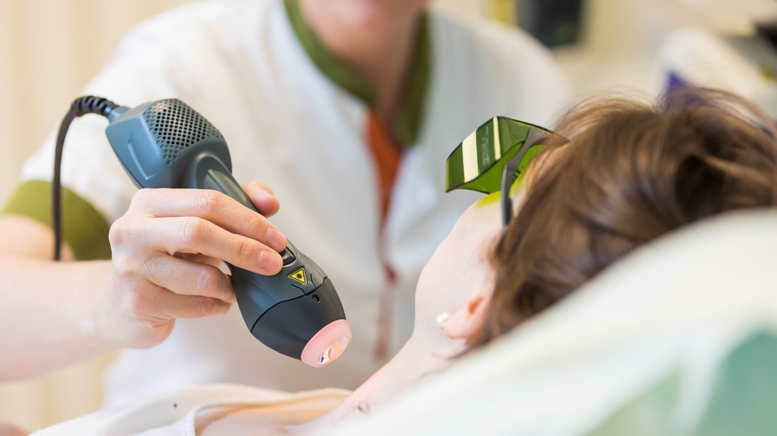 Patient being treated with handheld laser.